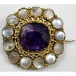 An antique yellow metal brooch set with moonstone