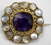 An antique yellow metal brooch set with moonstone