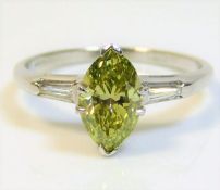 A fine marquise cut "fancy diamond" of 1.12ct with two fine white tapered diamonds to the shoulders