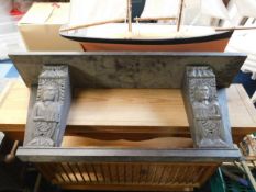 An antique oak shelf unit with carved figurative e