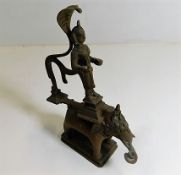 A brass Indian figure on elephant back with cobra