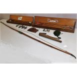 A vintage longbow with various accessories, badges