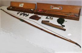 A vintage longbow with various accessories, badges