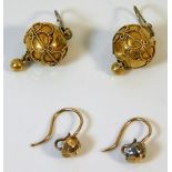 A pair of yellow metal earrings twinned with one o