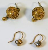 A pair of yellow metal earrings twinned with one o