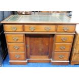 A nine drawer brass handled desk with cupboard und