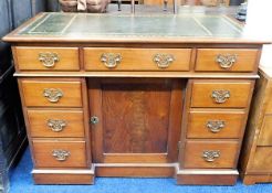 A nine drawer brass handled desk with cupboard und