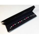 An 18ct gold necklace set with ruby & approx. 6ct of white diamonds with approx. 10ct of black diamo