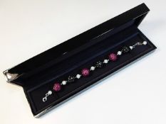 An 18ct gold necklace set with ruby & approx. 6ct of white diamonds with approx. 10ct of black diamo