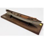 An good model of rowing boat set upon a wooden pli