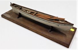 An good model of rowing boat set upon a wooden pli