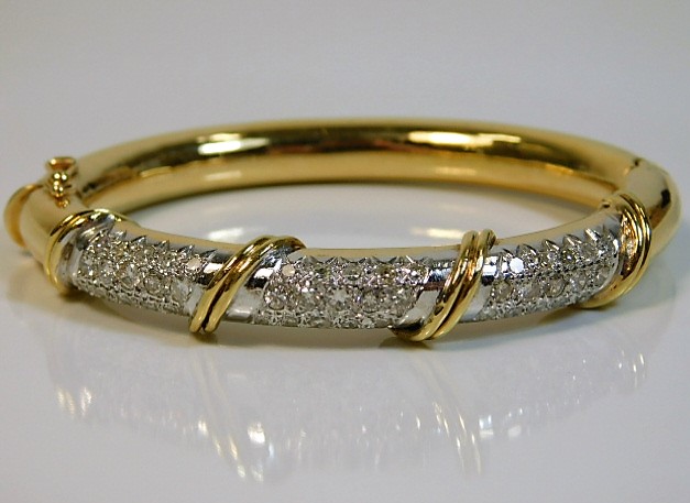 An 18ct gold bangle set with approx. 3ct of diamon