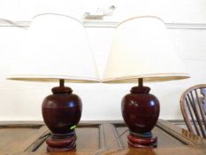 Two turned wooden lamps with brass mounted shades