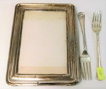 A silver picture frame, some dents, twinned with t