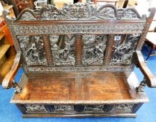 An early 19thC. oak settle with two part lift up s