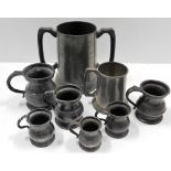 Six antique pot bellied pewter jugs, one later jug