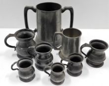 Six antique pot bellied pewter jugs, one later jug