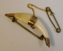 A 19thC. yellow metal mounted tooth, possibly a fo