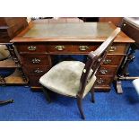 An antique pedestal desk with chair, fault to one