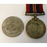 An WW2 medal twinned with a £5 crown
