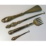 Four embossed silver handled items including a sho