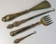 Four embossed silver handled items including a sho