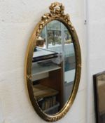 A decorative oval gilt mirror 26in