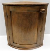 An antique curved oak corner wall cabinet with doo