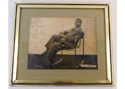 A framed photograph of Louis Armstrong, hand signe