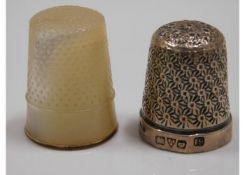 A silver thimble twinned with one yellow metal mou