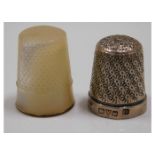 A silver thimble twinned with one yellow metal mou