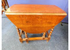 A 1920's oak drop leaf table with barley twist leg