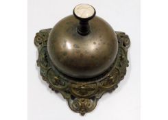 An antique brass desk service bell with ceramic in