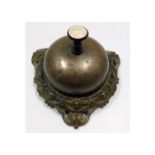 An antique brass desk service bell with ceramic in