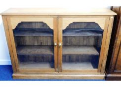 An antique low level glazed pine bookshelf 54in wi