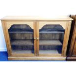 An antique low level glazed pine bookshelf 54in wi