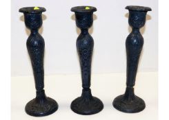 Three cast iron candle holders with relief decor p