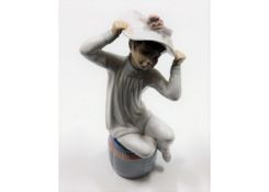 A Lladro porcelain figure of seated child with hat