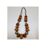 A large ethnic amber necklace with white metal fit