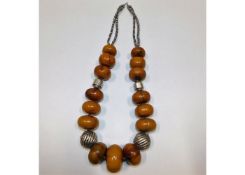A large ethnic amber necklace with white metal fit