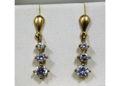 A pair of 9ct gold drop earrings with white stones