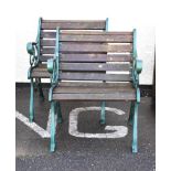 Two cast metal green painted garden seats having wooden slats