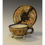 Satsuma tea cup and saucer, each piece decorated with seven figures and a dragon across two panels