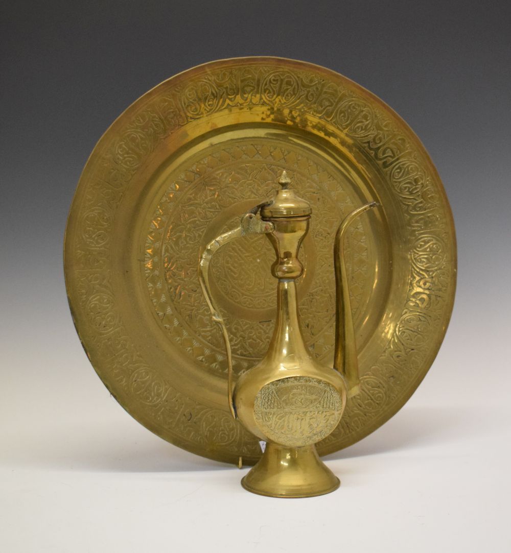 Middle Eastern brass charger with Arabic script, 42cm diameter and similar ewer, 31cm high