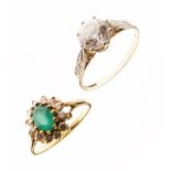 Yellow metal dress ring stamped 18k, with central green stone within a border of clear stones,