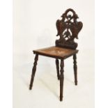 Late 19th/early 20th Century heavily carved oak hall chair having pierced eagle carved back, cane