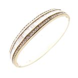 Yellow metal and diamond-set snap bangle, the hinged upper section set approximately two baguette-