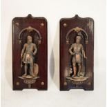 Pair of patinated metal figures of knights in armour on stained mahogany wall brackets, 58cm high