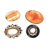 Four assorted brooches to include a Scottish-style hardstone panel brooch with large central