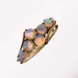 Yellow metal and opal dress ring set eight graduated circular cabochons in cross formation, shank